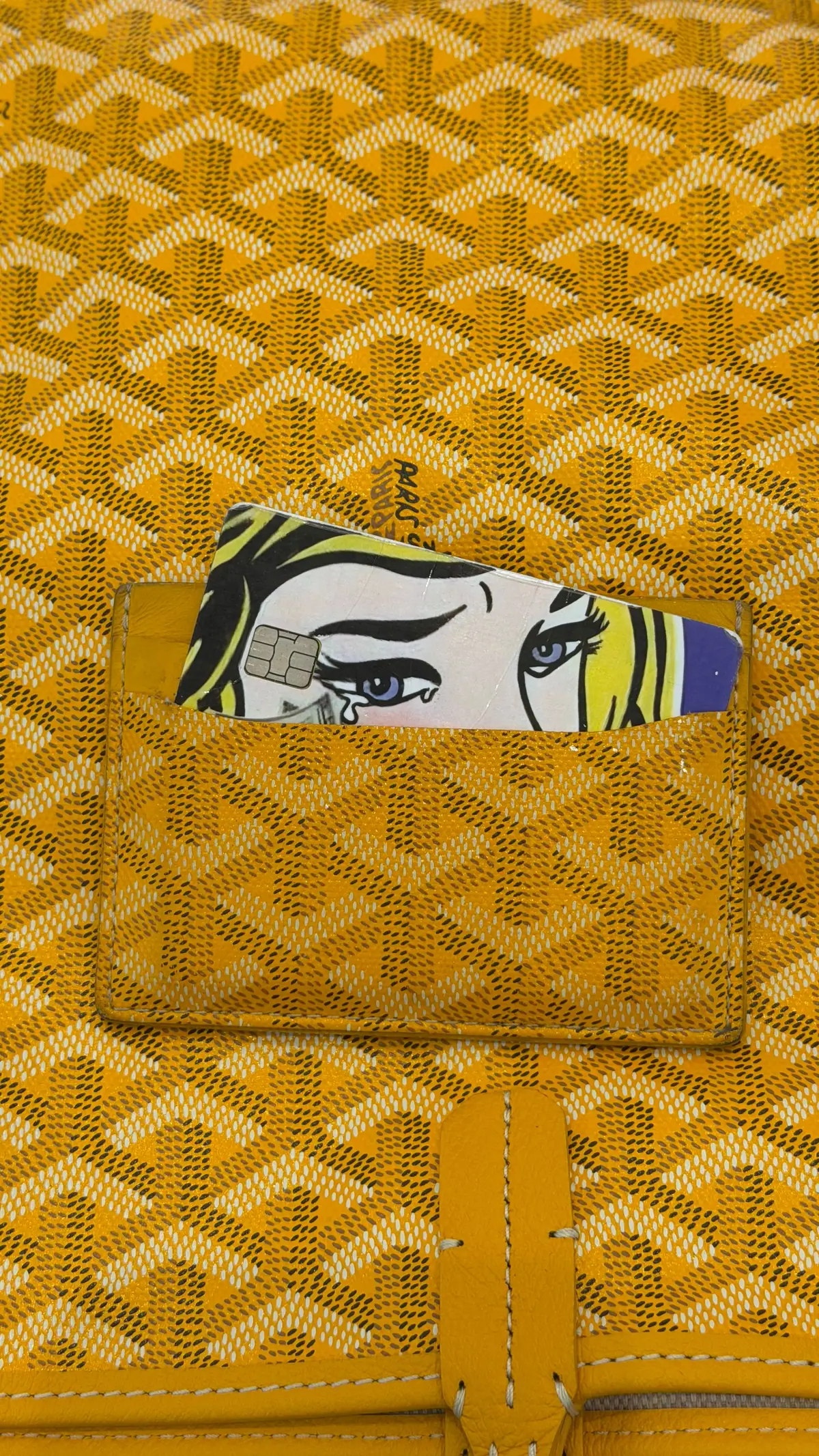 Yellow Goyard cardholder with a pop-art card