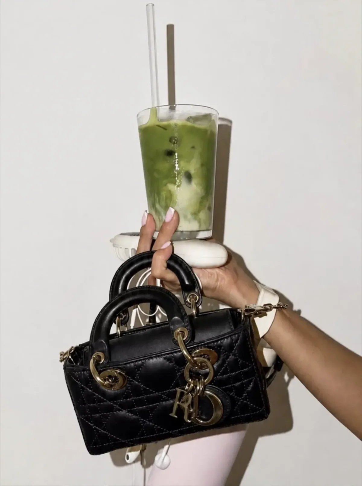 Quilted black top handle carried with an iced matcha