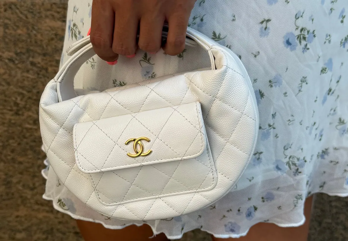 White Chanel mini bag carried against a floral dress